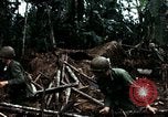 Immagine di I soldati degli Stati Uniti di smantellare e masterizzare il supporto NVA capanne in villaggio Il Vietnam, 1968, secondo 46 filmato di repertorio 65675021203