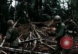 Immagine di I soldati degli Stati Uniti di smantellare e masterizzare il supporto NVA capanne in villaggio Il Vietnam, 1968, secondo 49 filmato di repertorio 65675021203