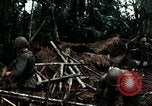 Immagine di I soldati degli Stati Uniti di smantellare e masterizzare il supporto NVA capanne in villaggio Il Vietnam, 1968, secondo 51 filmato di repertorio 65675021203
