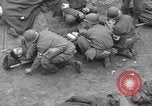 Image of Medics tend to wounded U.S. soldiers on beach Normandy France, 1944, second 24 stock footage video 65675022977