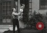 Image of man performs stunts on 9 months baby Los Angeles California USA, 1931, second 30 stock footage video 65675023610