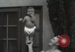 Image of man performs stunts on 9 months baby Los Angeles California USA, 1931, second 36 stock footage video 65675023610