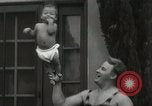 Image of man performs stunts on 9 months baby Los Angeles California USA, 1931, second 37 stock footage video 65675023610