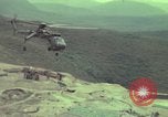 Image of 155mm howitzer slung beneath a CH-54 helicopter Vietnam, 1969, second 32 stock footage video 65675023785