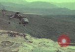 Image of 155mm howitzer slung beneath a CH-54 helicopter Vietnam, 1969, second 33 stock footage video 65675023785