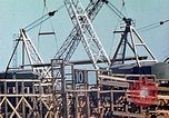 Image of Mobile cranes move ship's deck section at shipyard in World War California United States USA, 1942, second 15 stock footage video 65675025791