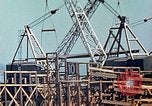 Image of Mobile cranes move ship's deck section at shipyard in World War California United States USA, 1942, second 17 stock footage video 65675025791
