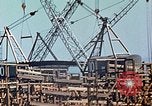 Image of Mobile cranes move ship's deck section at shipyard in World War California United States USA, 1942, second 33 stock footage video 65675025791