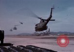 Image of UH-1Ds' and UH-1Bs' helicopters landing US troops during Operation Att Dau Tieng Vietnam, 1966, second 16 stock footage video 65675026866