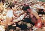 Image of Marine renders first aid to wounded buddy Saipan Northern Mariana Islands, 1944, second 1 stock footage video 65675028048