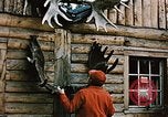 Image of Moose antlers being fastened to a log cabin Alaska USA, 1954, second 6 stock footage video 65675034930