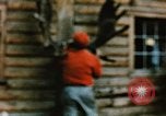 Image of Moose antlers being fastened to a log cabin Alaska USA, 1954, second 41 stock footage video 65675034930