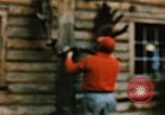 Image of Moose antlers being fastened to a log cabin Alaska USA, 1954, second 49 stock footage video 65675034930