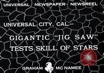 Standbild Hollywood Stars Montage einer Stichsäge Puzzle Universal City California USA, 1933, aus Sekunde 3 historischem Filmmaterial Videoclip 65675037678