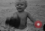 Image of boy on sandy beach United States USA, 1936, second 26 stock footage video 65675047809