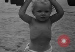 Image of boy on sandy beach United States USA, 1936, second 27 stock footage video 65675047809