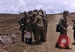 Image of American soldiers search a Japanese youth in uniform Saipan Northern Mariana Islands, 1944, second 17 stock footage video 65675050873