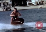 Image of motorboat pulling man and woman balanced on aquaplane United States USA, 1939, second 12 stock footage video 65675051556
