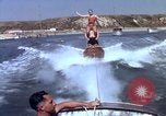 Image of motorboat pulling man and woman balanced on aquaplane United States USA, 1939, second 28 stock footage video 65675051556