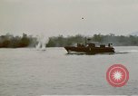 Image of explosions along riverbank Vietnam, 1966, second 57 stock footage video 65675055555