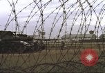 Image of view through barbed wire at airbase operations Vietnam, 1967, second 33 stock footage video 65675061936