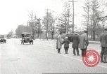 Image of An automobile almost hits pedestrians in center of a road Michigan United States USA, 1916, second 13 stock footage video 65675064462
