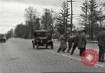 Image of An automobile almost hits pedestrians in center of a road Michigan United States USA, 1916, second 15 stock footage video 65675064462