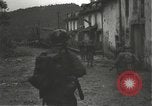Immagine di Japanese-American fanti mobile attraverso una città Bruyeres Francia, 1944, secondo 13 filmato di repertorio 65675065584