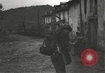 Immagine di Japanese-American fanti mobile attraverso una città Bruyeres Francia, 1944, secondo 15 filmato di repertorio 65675065584