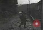 Immagine di Japanese-American fanti mobile attraverso una città Bruyeres Francia, 1944, secondo 38 filmato di repertorio 65675065584