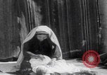 Image of mother wraps baby in swaddle Bethlehem Palestine, 1941, second 33 stock footage video 65675079605